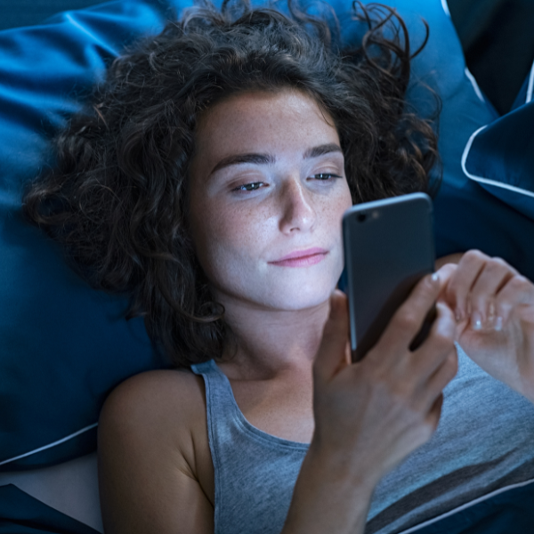 Child using a phone screen in the dark before bed