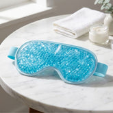 Eyehouse reusable hot and cold gel bead eye mask, resting on the white marble side table